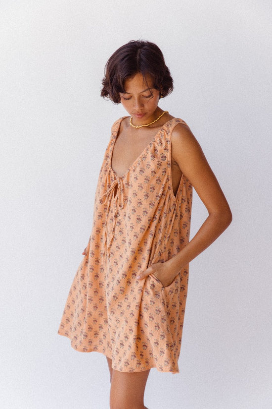 Sundress Mini Peach — close-up neckline tie detail, adjustable gathered bow at neckline, peach floral block print cotton fabric detail, handcrafted artisan India | Daughters of India