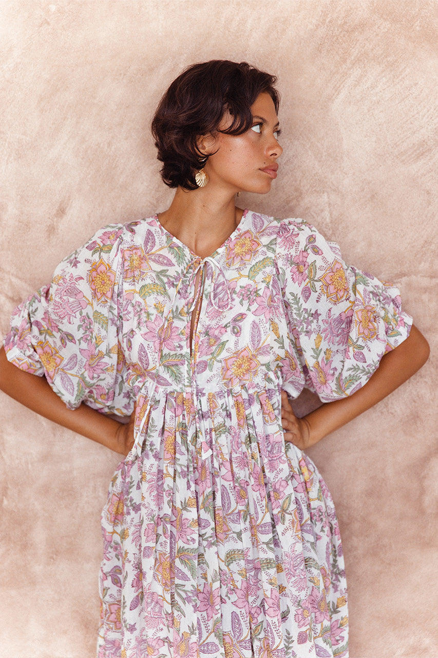 Daughters of India Kyra Midi Dress in Fuchsia Bloom — close-up neckline tie and billowed sleeves by terracotta wall